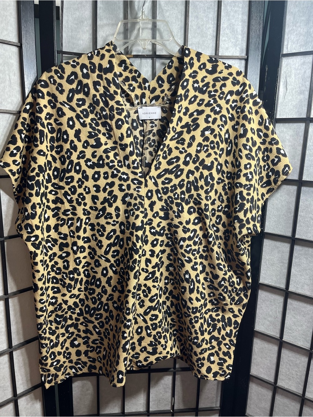 Adrienne brand top features a distinct V-neckline and a vibrant all-over leopard